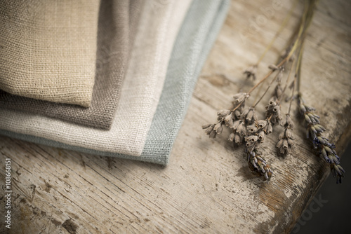 Stack of Folded Linen by Edge of Wooden Table photo