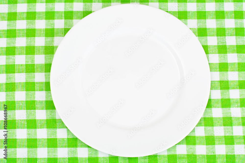 White Plate on a Checkered Tablecloth with Place for Your Text White Plate on a Checkered Tablecloth with Place for Your Text