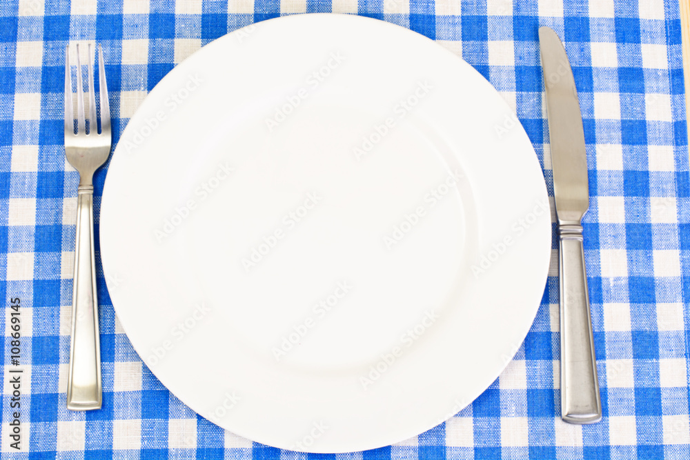 White Plate on a Checkered Tablecloth with Place for Your Text White Plate on a Checkered Tablecloth with Place for Your Text