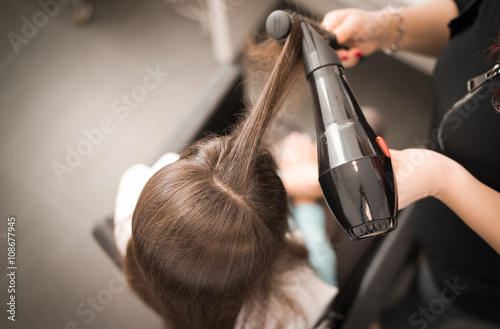 Detail of drying hair with hair dryer and brush.