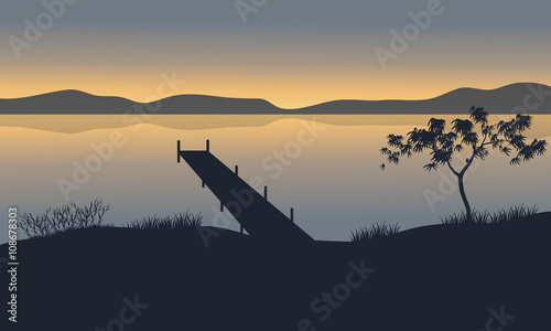 Silhouette of pier in lake