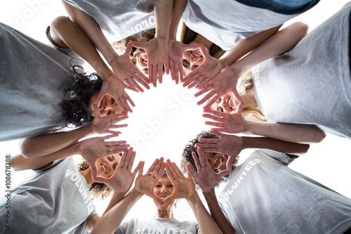 Schilderij op canvas Happy volunteers standing in a circle with their hands together