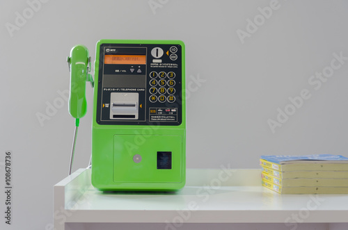 Green publc telephone on table
