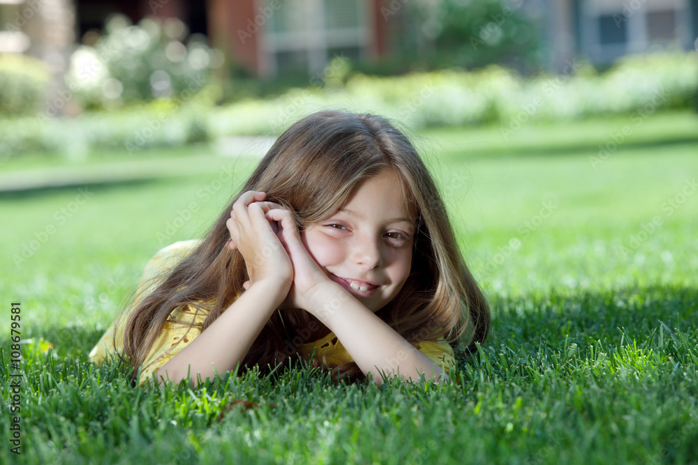 portrait of little girl laying on the grass in summer environment portrait of little girl laying on the grass in summer environment