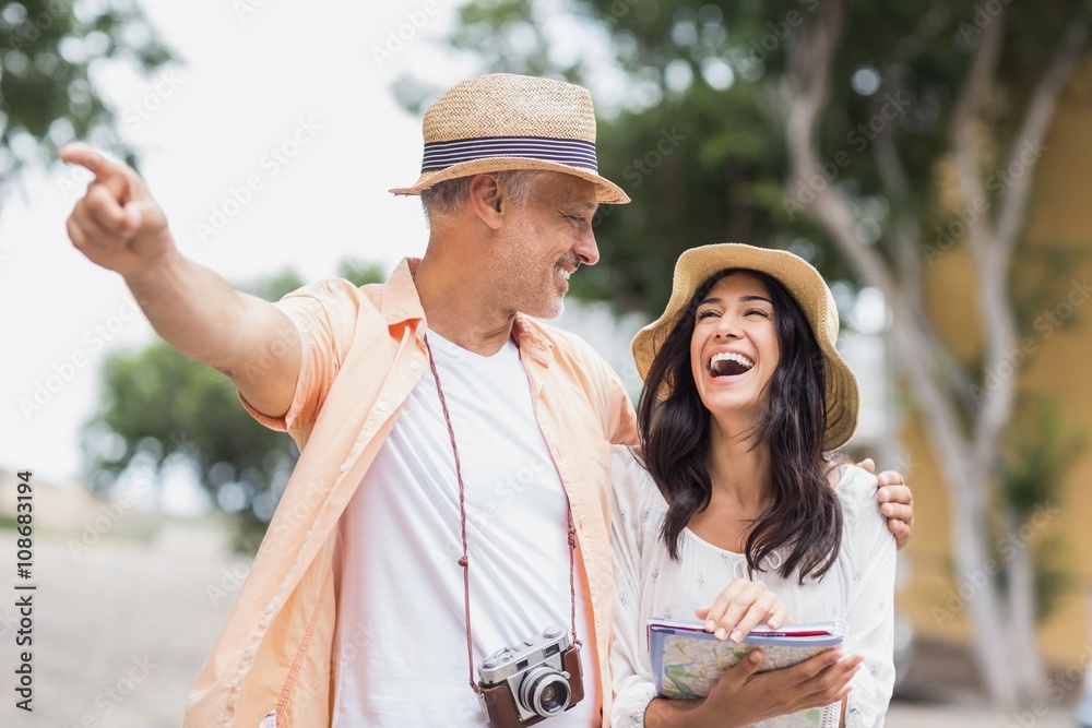 Man looking at cheerful woman while pointing away