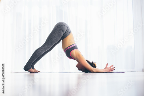 Ardha shirshasana. Beautiful yoga woman practice in a training hall background. Yoga concept.