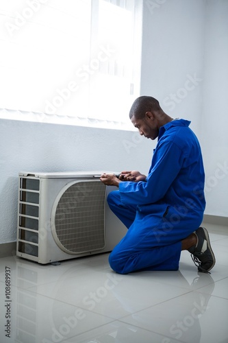 Handyman testing air conditioner