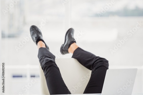Businessman lying on ground with his feet up