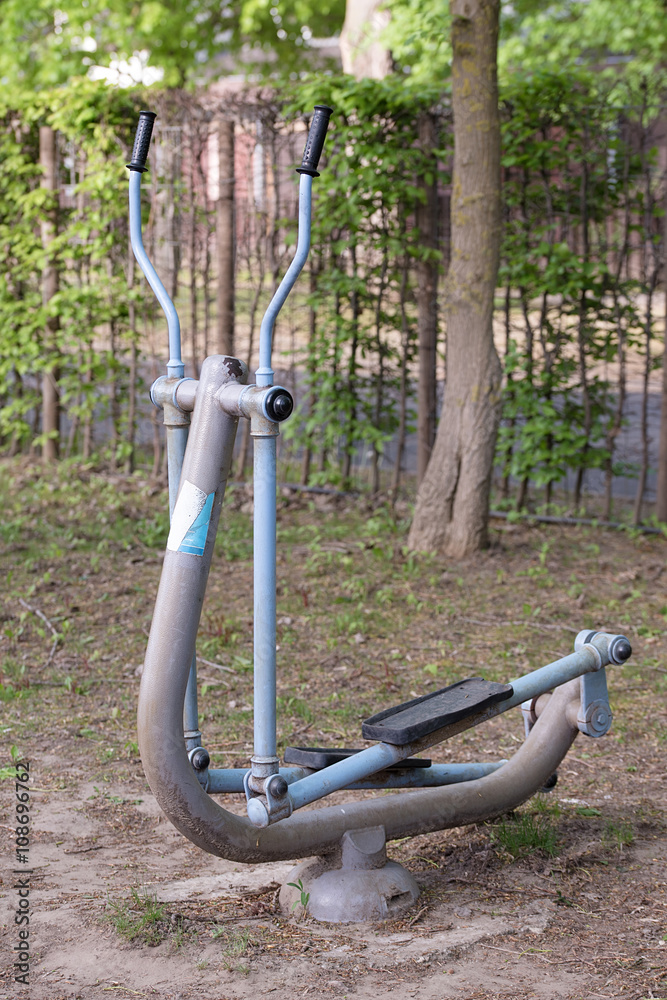 Old iron elliptical trainer in park