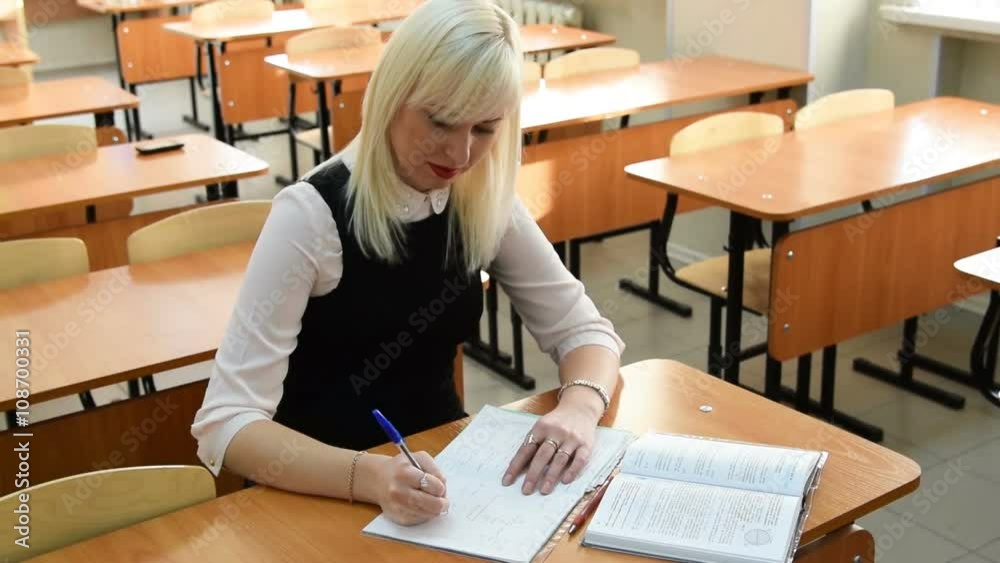 Young student taking notes from book in the classroom Young student taking notes from book in the classroom