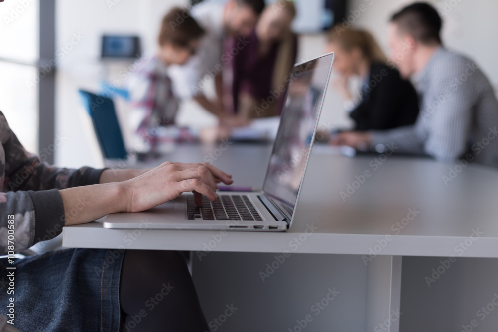 close up of business womans hand typing on laptop with team on m close up of business womans hand typing on laptop with team on m