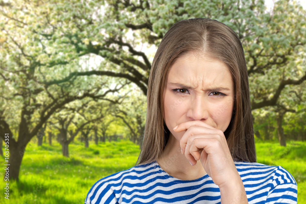 Portrait of a young woman holding her nose
