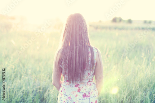 Beautiful girl field green meadow in summer park delicate dress, enjoying leisure, fashion style, glamor life,  student at a bright sunny day.