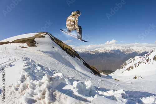 Snowboard rider jumping on mountains. Extreme snowboard freeride sport.