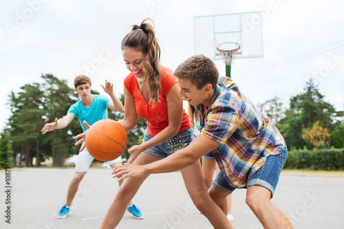 group of happy teenagers playing basketball © Syda Productions