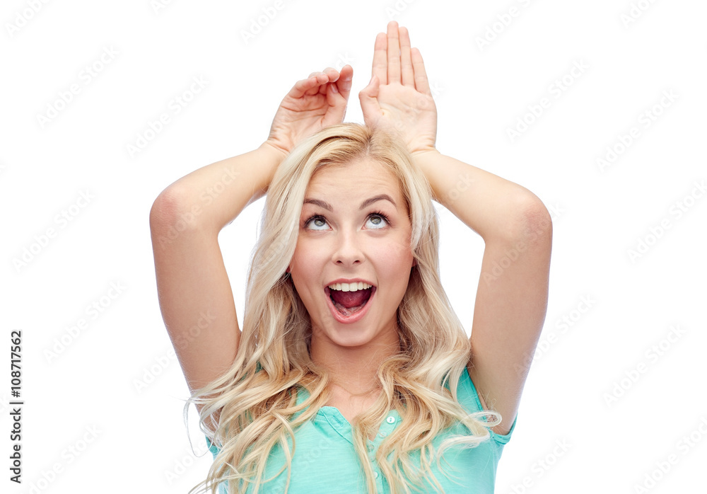 happy smiling young woman making bunny ears happy smiling young woman making bunny ears