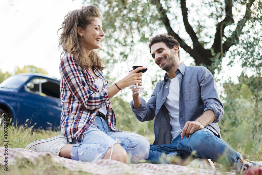 Young couple in love doing a picnic outdoors in Tuscany wine country