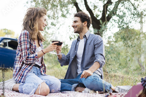 Young couple in love doing a picnic outdoors in Tuscany wine country playing music with a guitar © juripozzi