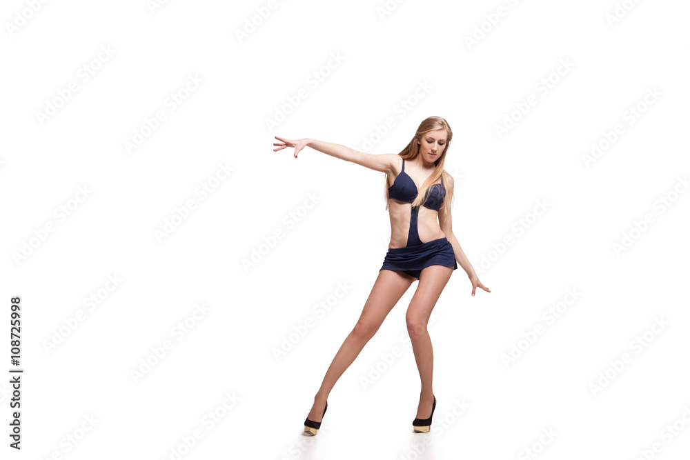 Young beautiful dancer posing on studio background