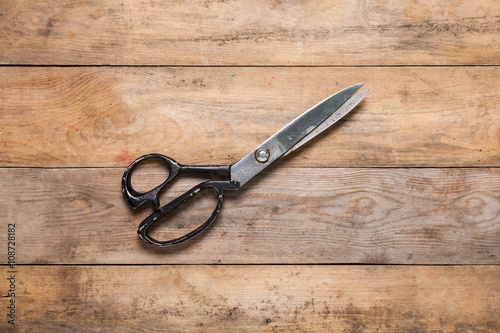 Scissors on aged wooden table