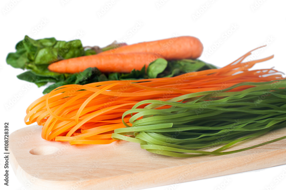 Orange and green raw italian pasta with spinach and carrot