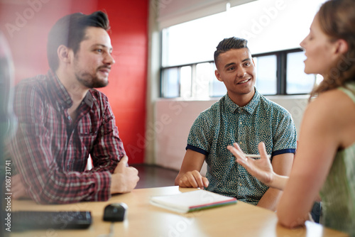 Unposed group of creative business people in an open concept office brainstorming their next project. photo