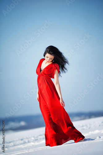 beautiful girl in a red dress on the snow