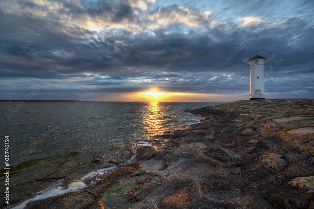 Fototapeta premium Lighthouse windmill Stawa Mlyny in Swinoujscie, Baltic Sea, Poland.