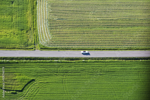 Aerial view of car on road by fields