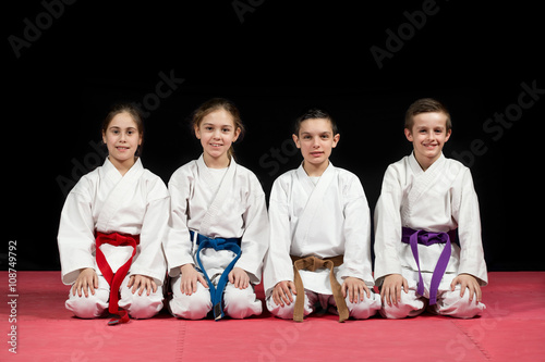 Children in kimono sitting on tatami on martial arts seminar. Selective focus photo