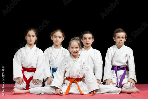 Children in kimono sitting on tatami on martial arts seminar. Selective focus