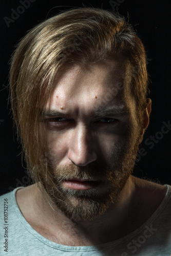 Portrait of a angry young man pointing on gray wall background © maxbelchenko