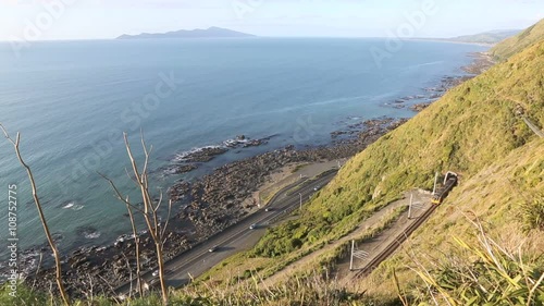 Metro commuter train and traffic on scenic highway along Kapiti coast, New Zealand 