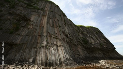 Lonely man shoots photo near Pillars cape rock Kunashir, Kuril islands
