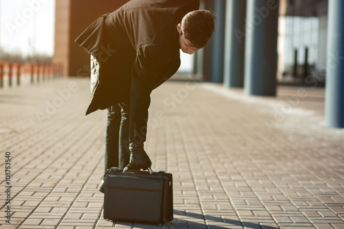 Businessman walking and holding a leather briefcase in his hand 