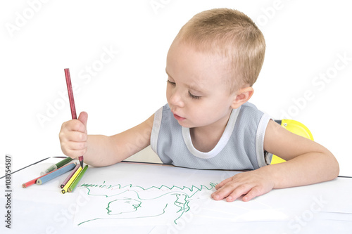 Little boy drawing with crayons. Isolated on a white background. photo