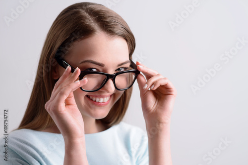 Positive girl holding her glasses