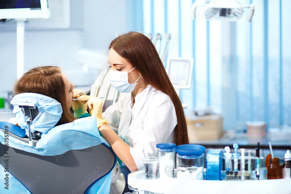 Obraz premium Professional woman dentist doctor working . woman at dental clinic. lady woman at dentist taking care of teeth.Dental care for people. Dentist holding dental device for fixing teeth. 