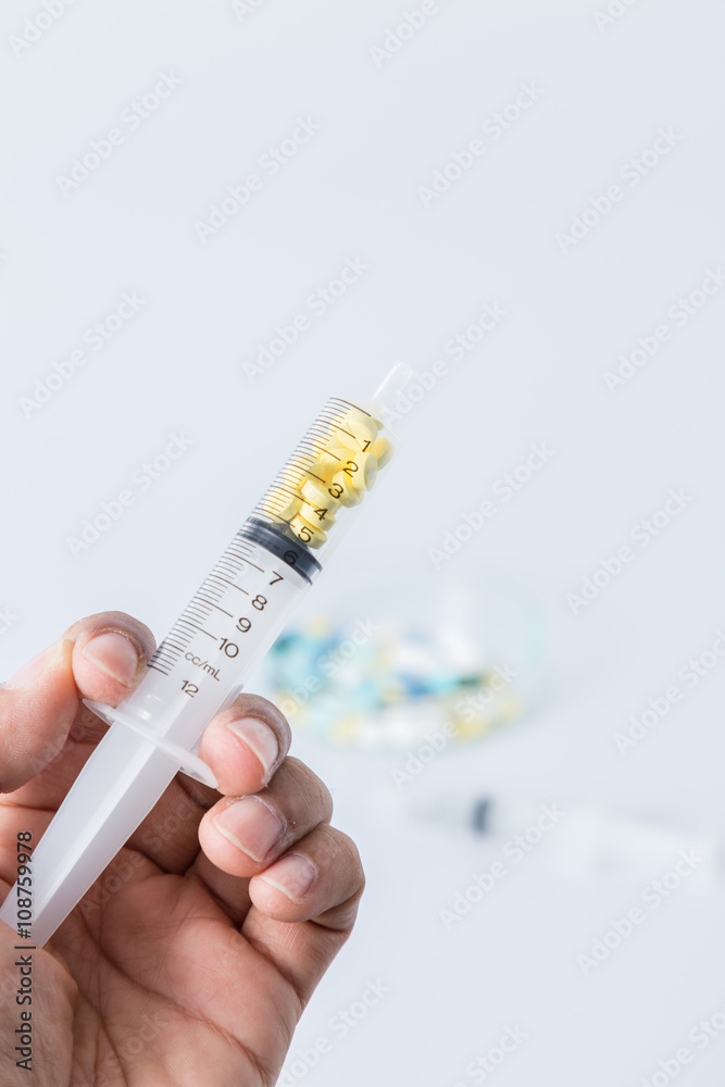 closeup of syringe with spoon on many pills and capsules for hea closeup of syringe with spoon on many pills and capsules for hea