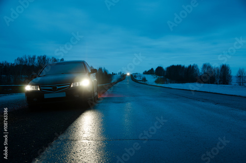 black sports car in the rain at night road