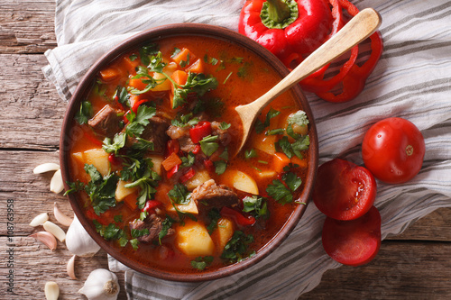 Traditional Hungarian goulash soup bogracs close-up in a bowl. Horizontal top view 