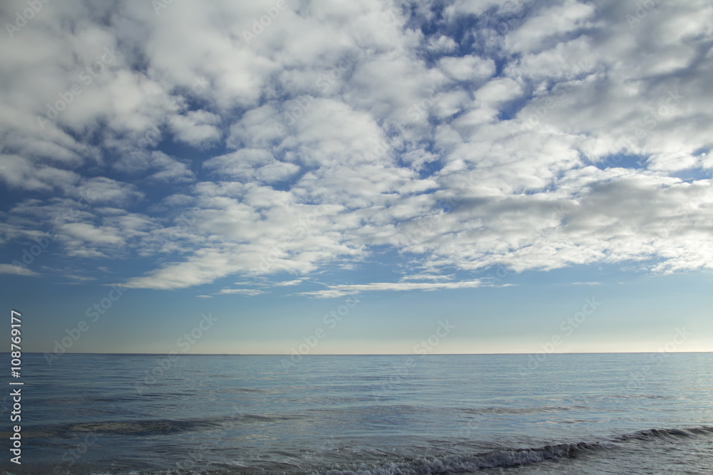 Stratocumulus clouds over blue sea water waves