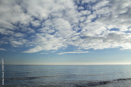 Stratocumulus clouds over blue sea water waves