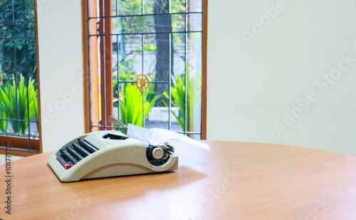 a typewriter on a round table with a background in multiple windows