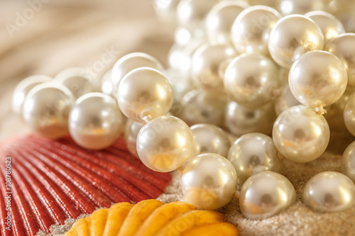 White pearl and seashells on sand