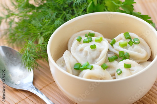 Meat pelmeni with butter and spring onion