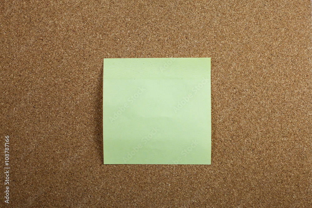Yellow sticky note on cork board Yellow sticky note on cork board