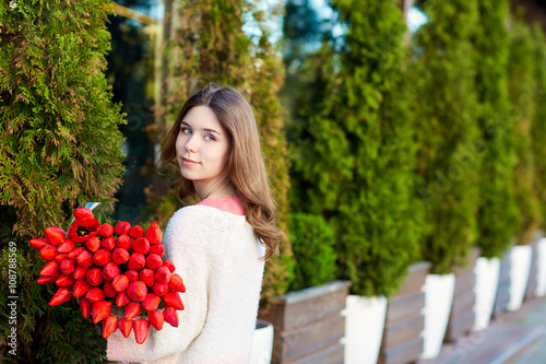 Romantic girl with a bouquet of red tulips