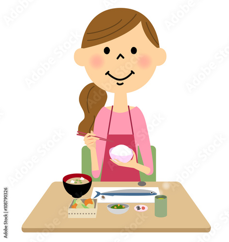 ご飯を食べるエプロンの女性