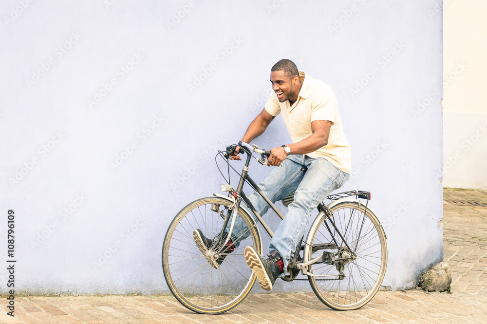 African american guy having fun and good time with vintage bicycle outdoors